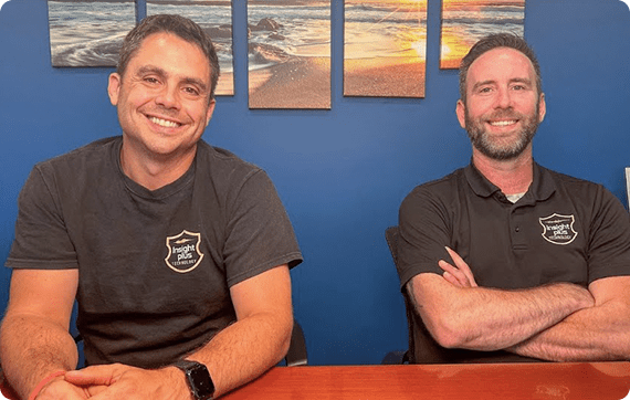 Ryan McKenna and Tom Holtz sitting at a table, smiling